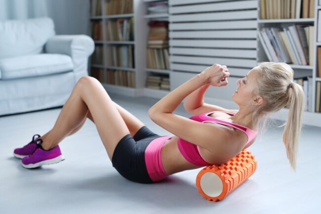 blonde-woman-workout-exercises-with-foam-roller_144627-18936