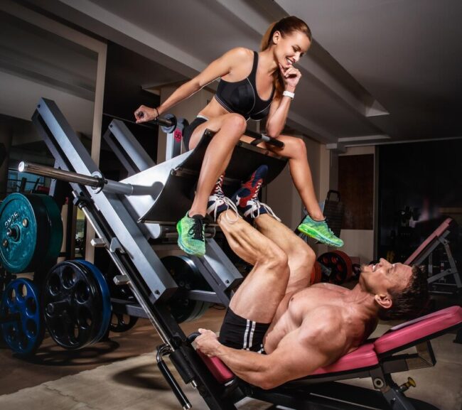 man-weightlifter-doing-leg-presses-with-his-trainer-sports-couple-is-working-out-gym_613910-2600